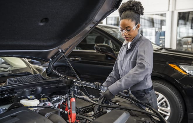 A service technician testing a car battery
